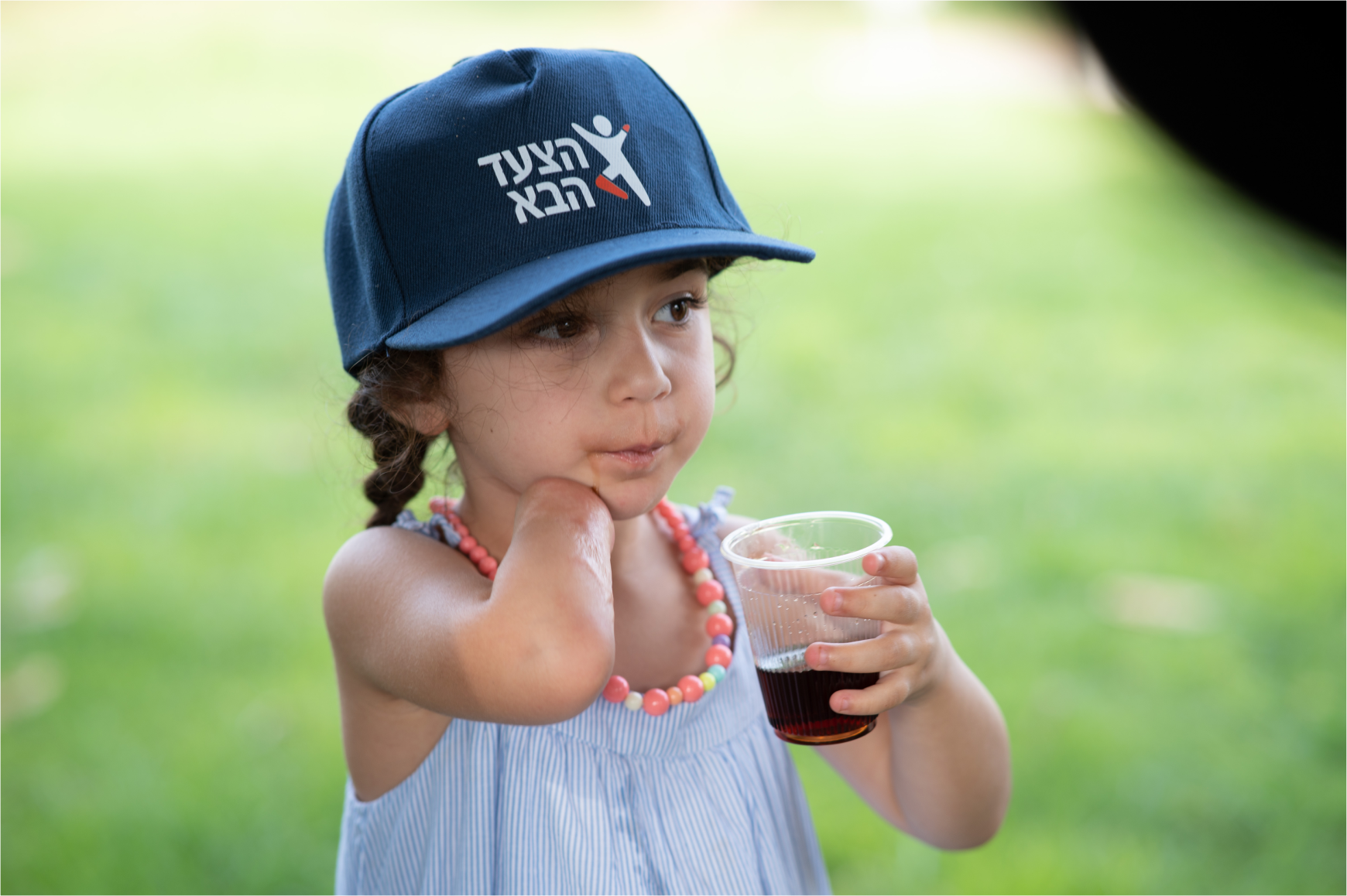 A young girl in a Next Step cap
